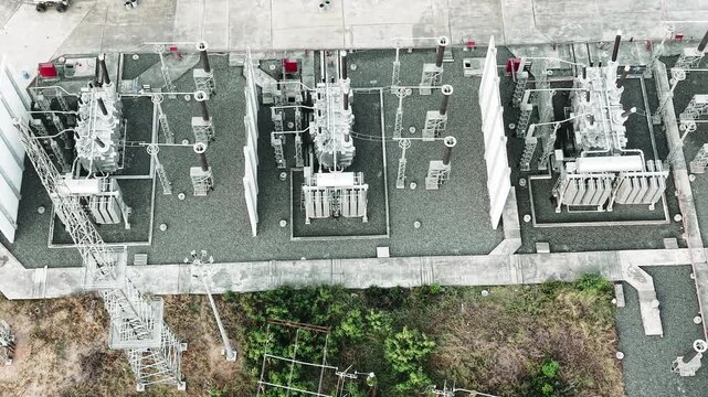 Drone video of electrical transformers lined up in a row with clear spacing and organization