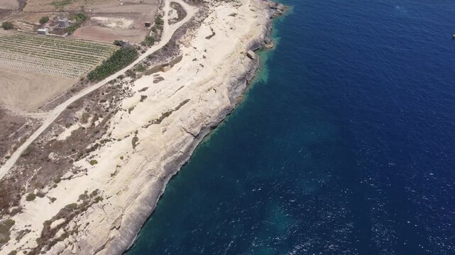 Xatt L-Ahmar, Gozo, Malta. Salt apns. serene aerial view of rocky coastline with sandy beaches and calm waters in natural setting for travel and vacation purposes. stationery perspective from above