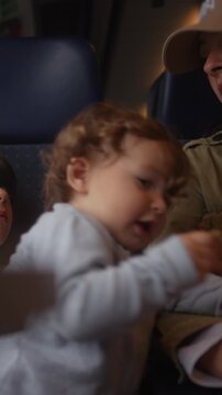 Mother handing snack to toddler during passenger train journey, highlighting nurturing, healthy nutrition and everyday family travel
