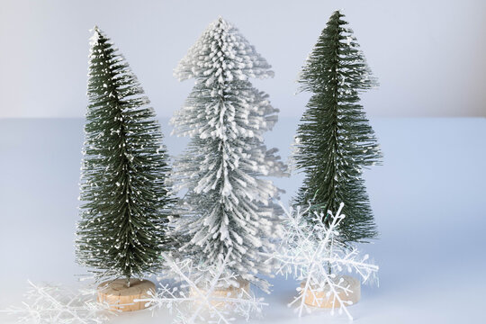Large snowflakes and three miniature trees, one snow covered.  Minimalism.  Simple holiday background or greeting.