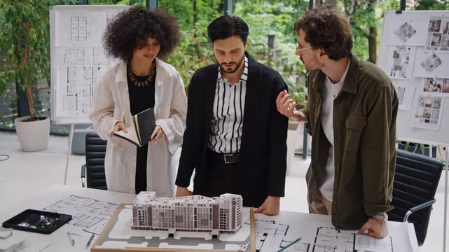 Architectural designers gather around model of residential houses