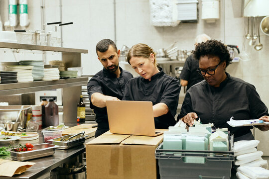 Group of chefs taking inventory while working in commercial kitchen
