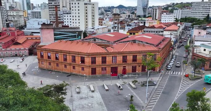 4K drone aerial view of Juiz de Fora Municipal Market in Minas Gerais, Brazil, showcasing historic architecture and the downtown district.
