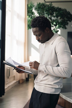 Male entrepreneur reviewing paperwork and documents at office