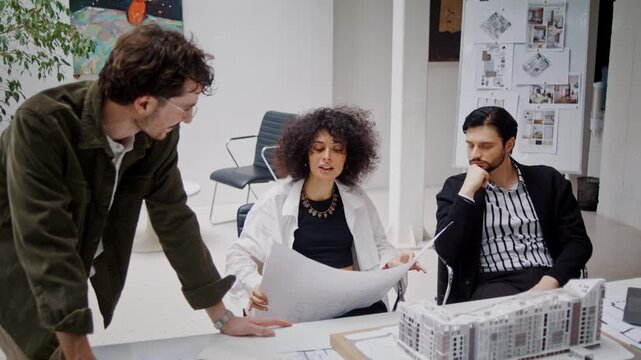 Woman architectural designer examines blueprint on drawing sheet