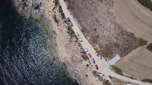 Xatt L-Ahmar, salt pans, Gozo island, Malta. serene aerial view of rocky coastline with clear blue ocean waves and sandy shorelines during a peaceful vacation in nature. High quality 4k footage