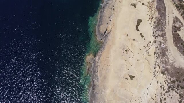 Xatt L-Ahmar, Gozo, Malta. Salt apns. serene aerial view of rocky coastline with sandy beaches and calm waters in natural setting for travel and vacation purposes. stationery perspective from above