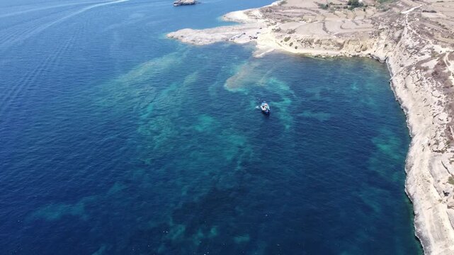 Ras il-Hobz salt pans, aerial shot , Gozo, Malta. serene aerial view of a coastal landscape with water and land, featuring blue and green hues and natural vegetation. High quality 4k footage