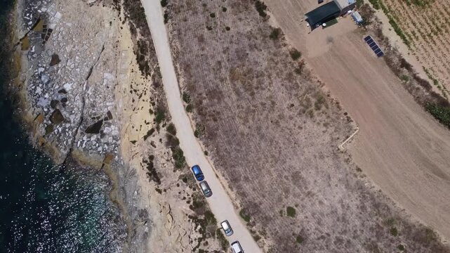 Xatt L-Ahmar, salt pans, Gozo island, Malta. serene aerial view of rocky coastline with clear blue ocean waves and sandy shorelines during a peaceful vacation in nature. High quality 4k footage