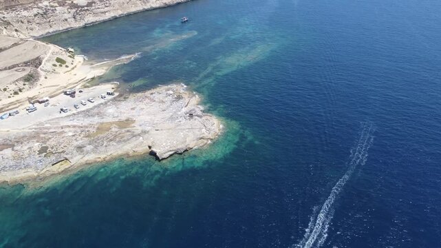 Ras il-Hobz salt pans, aerial shot towards Xatt L-Ahmar salt pans, Gozo, Malta. serene aerial view of a coastal landscape with water and land, featuring blue and green hues and natural vegetation