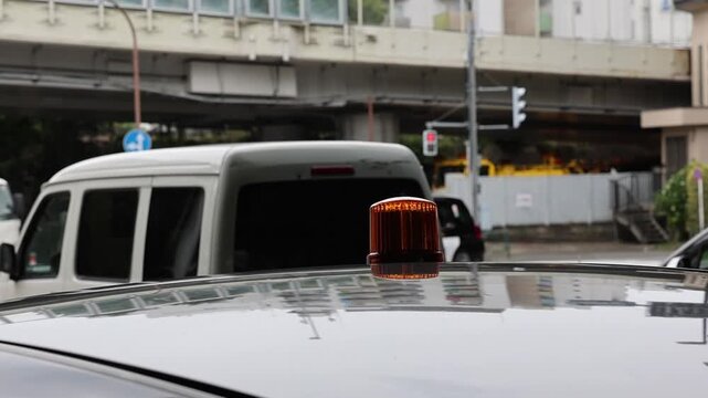 A flashing light on top of a car in Japan.