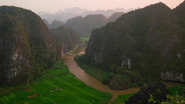 Stunning view from top of Mua Cave/Hang Mua of Tam Coc valley with lime stones and water way surrounded by rice fields in Ninh Binh, North Vietnam