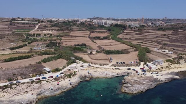 Xatt L-Ahmar, Gozo, Malta. Salt apns. serene aerial view of rocky coastline with sandy beaches and calm waters in natural setting for travel and vacation purposes. stationery perspective from above
