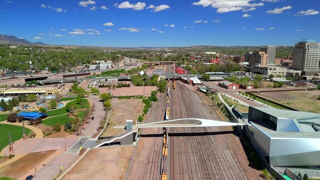 Drone flyalong beside freight train with wind turbine blades on rail in Colorado Springs