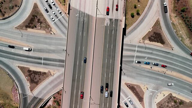 Top down drone shot of busy multilane highway interchange with moving vehicles in Colorado