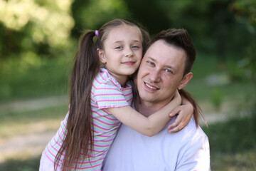 Fototapeta premium Family portrait of smiling father and his daughter outdoors