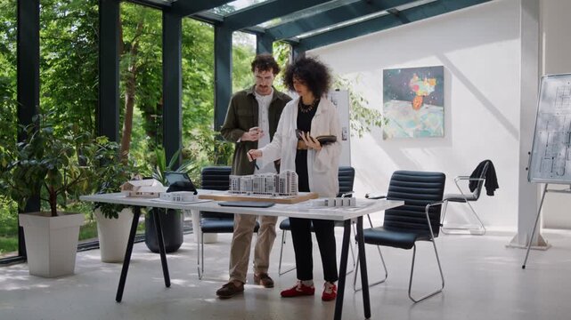 Man engineer demonstrates building model to woman inspector
