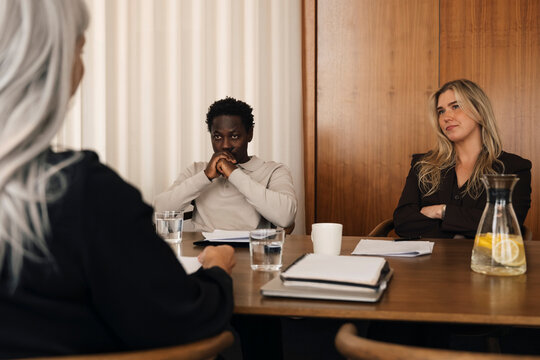 Serious couple sitting table during legal separation process with lawyer