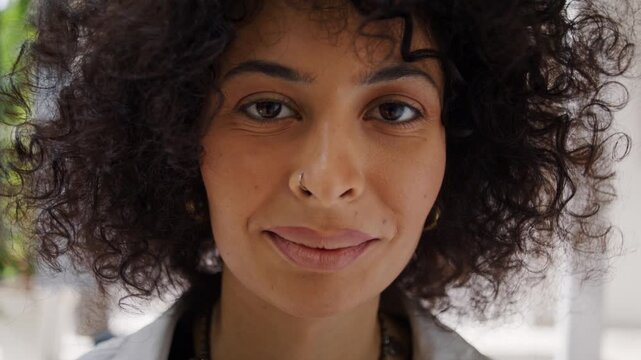 Pretty African American woman with kinky hair smiles in office