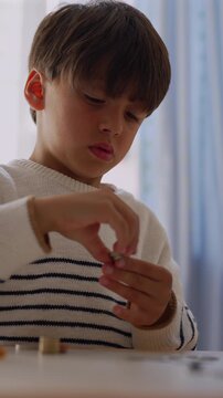 Young boy sorting coins at home, highlighting early math skills, financial awareness and childhood responsibility
