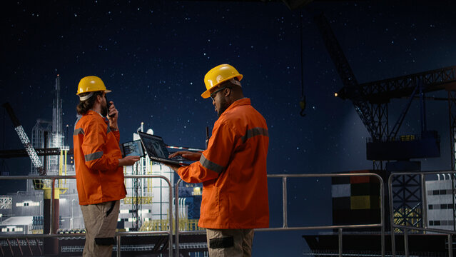 Offshore platform workers using map on laptop to circumvent embargo slowing fuel extraction operations, camera A.