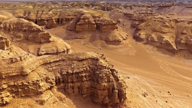 Scenic aerial view of unique yardang landforms and red rock canyons in Xinjiang, China, showcasing geological erosion and dry desert terrain.