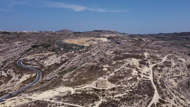 Aerial view of Dwerja bay in Gozo at noon with clear skies and rock formations brown and gray earth tones and natural beauty for nature documentarie. High quality 4k footage