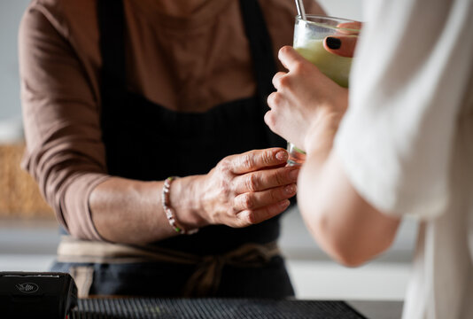 Woman Bartender Handing Customer Matcha Latte Glass