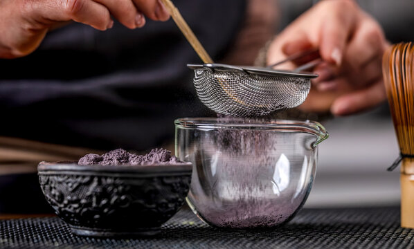 Woman Sifting Blue Matcha Through Sieve