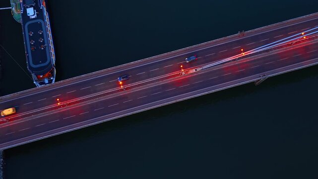Cable stayed Most SNP bridge tower over Bratislava at night. High angle perspective of the illuminated observation deck with road traffic during twilight.