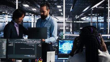 Fototapeta premium Team of server room engineers working with machine learning models to review extensive data sets.