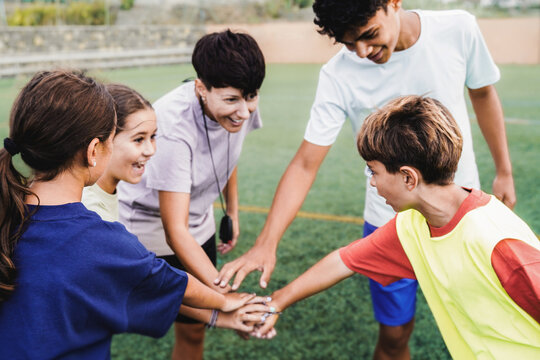 Happy soccer team stacking together outdoor - Children players having fun during football match