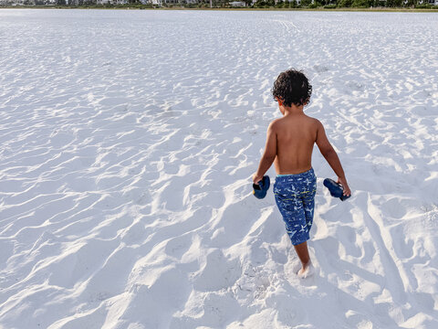 Child walking on the beach sand - Travel vacations concept