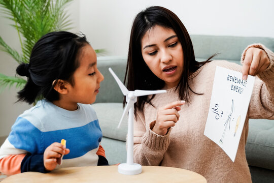 Asian mother working with her child on renewable energy project for school science class at home