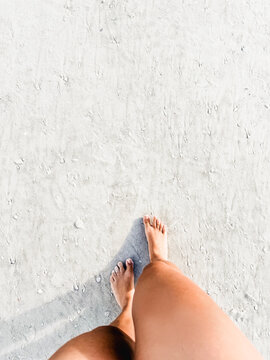 POV woman walking on sand beach - Feet and legs top view - Travel vacations