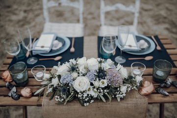 Beach wedding table with navy runners and a floral centerpiece © LeifOliver