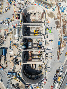 Aerial view of Old Oak Common station HS2 construction site with deep excavation pits, heavy machinery, and concrete structures in London, England, United Kingdom.