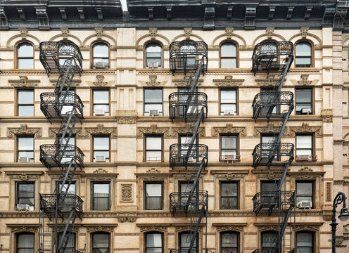 New York City, gentrified old apartment building with ornate window frames and external fire escape