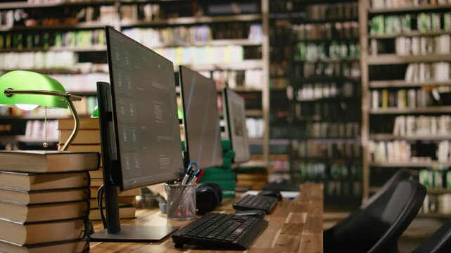 Business conference screen with abstract blue background and chatbot on two monitors at library study desk with keyboard, books and headphones, academic workspace, for education technology.