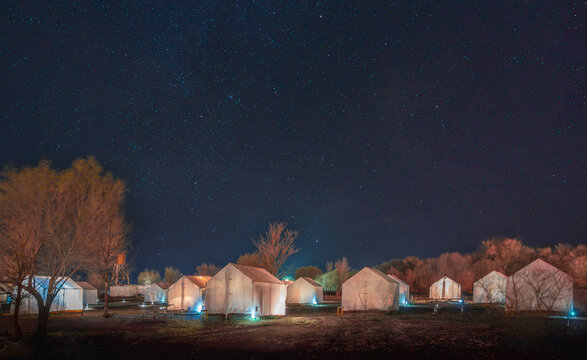 Canvas tent campground under night sky with stars. Copy space.
