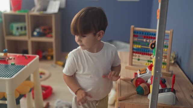 Boy playing with wooden toys and abacus, hand on table in a bright playroom inside a building; childhood joy curiosity.