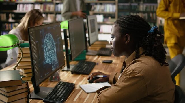 Black student working with AI brain display on desktop in library, studying automation in computer class with peers, for education technology.