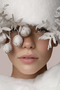 Close-up portrait of a young woman with winter-themed decoration and soft features  