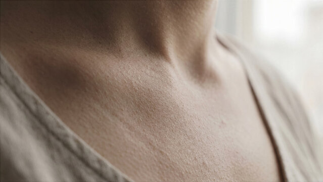 Extreme macro shot of human neck area during deep breathing exercise collarbone motion
