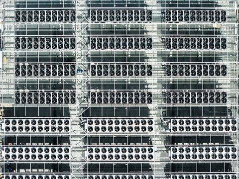 Aerial view of the industrial cooling fan array on the roof of a data center in Riga, Latvia.
