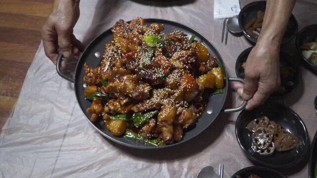 A close-up of Korean braised chicken jjim dak with vegetables and sauce in a dark pan ready to be served.