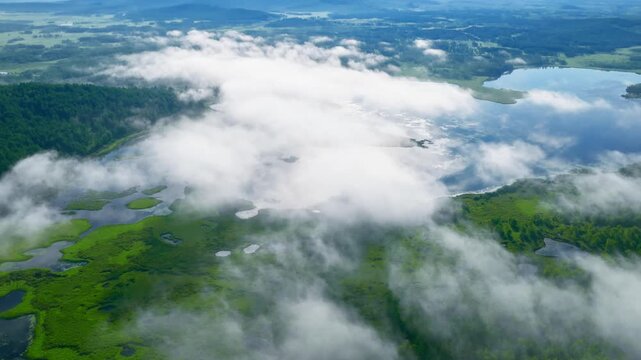 Aerial view of misty clouds over lush wetlands and lakes