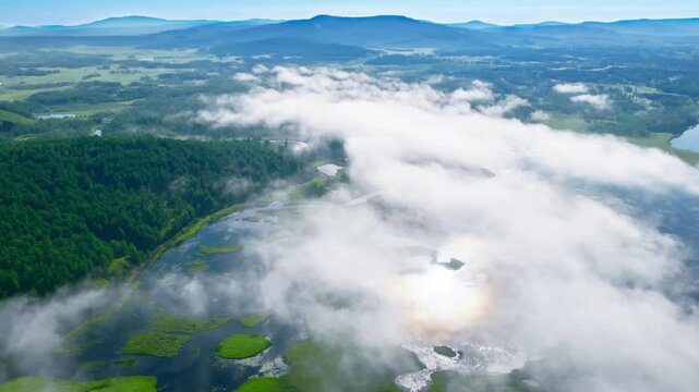 Aerial View of Winding River Through Cloud-Covered Wetlands