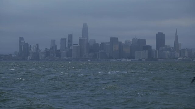 San Francisco Skyline from Bay Of Choppy Waves With Hazy Overcast - Wide Shot