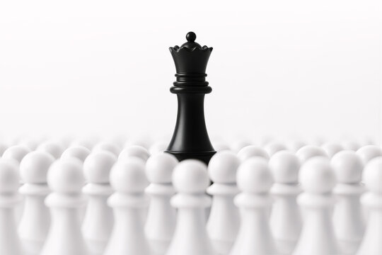 Black queen chess piece surrounded by white pawns. Strategy, opposition, power imbalance, leadership under pressure and competitive challenge concept